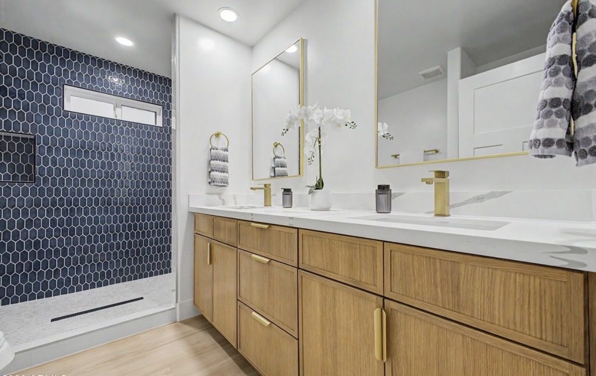Bathroom with floating oak vanity and blue hex-tile shower