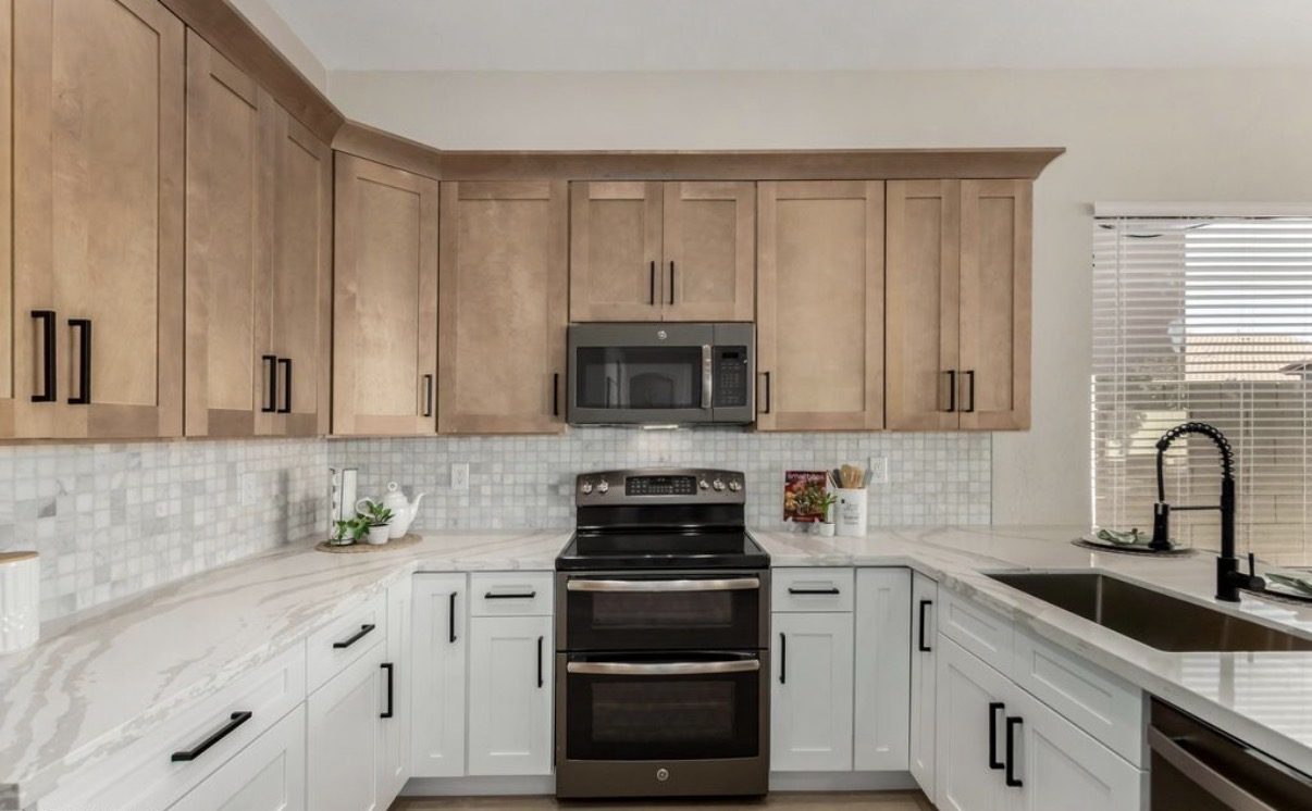 Two-tone kitchen with oak upper cabinets and white shaker base