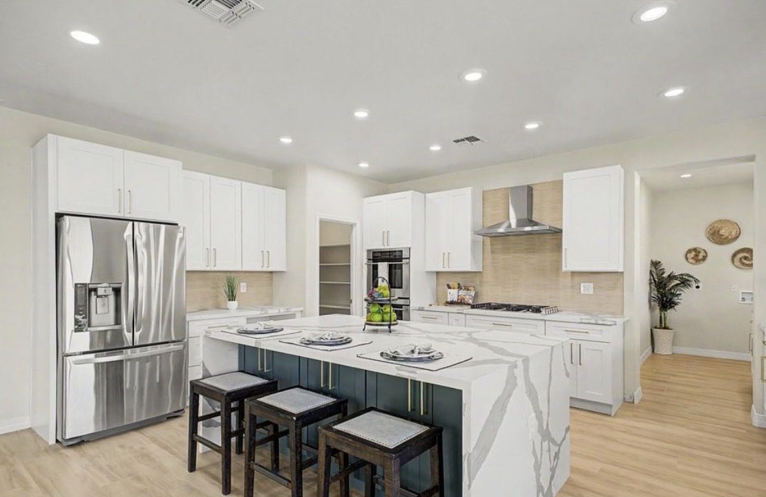 Custom white shaker kitchen with navy waterfall island and quartz counters