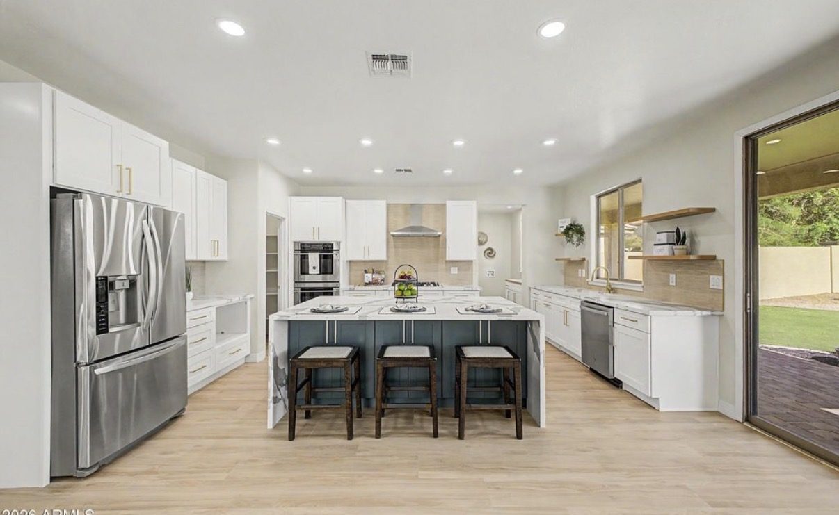 Custom kitchen with white shaker cabinets and navy island