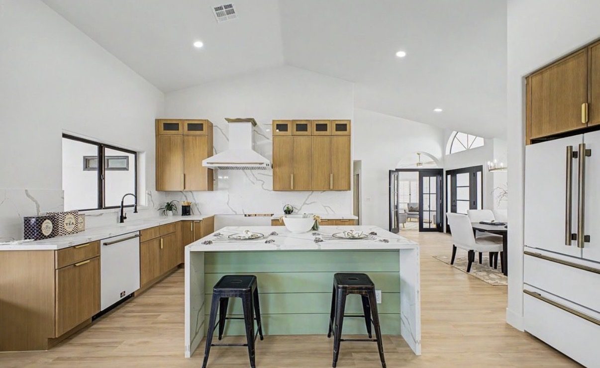 Vaulted kitchen with white oak cabinetry and waterfall island